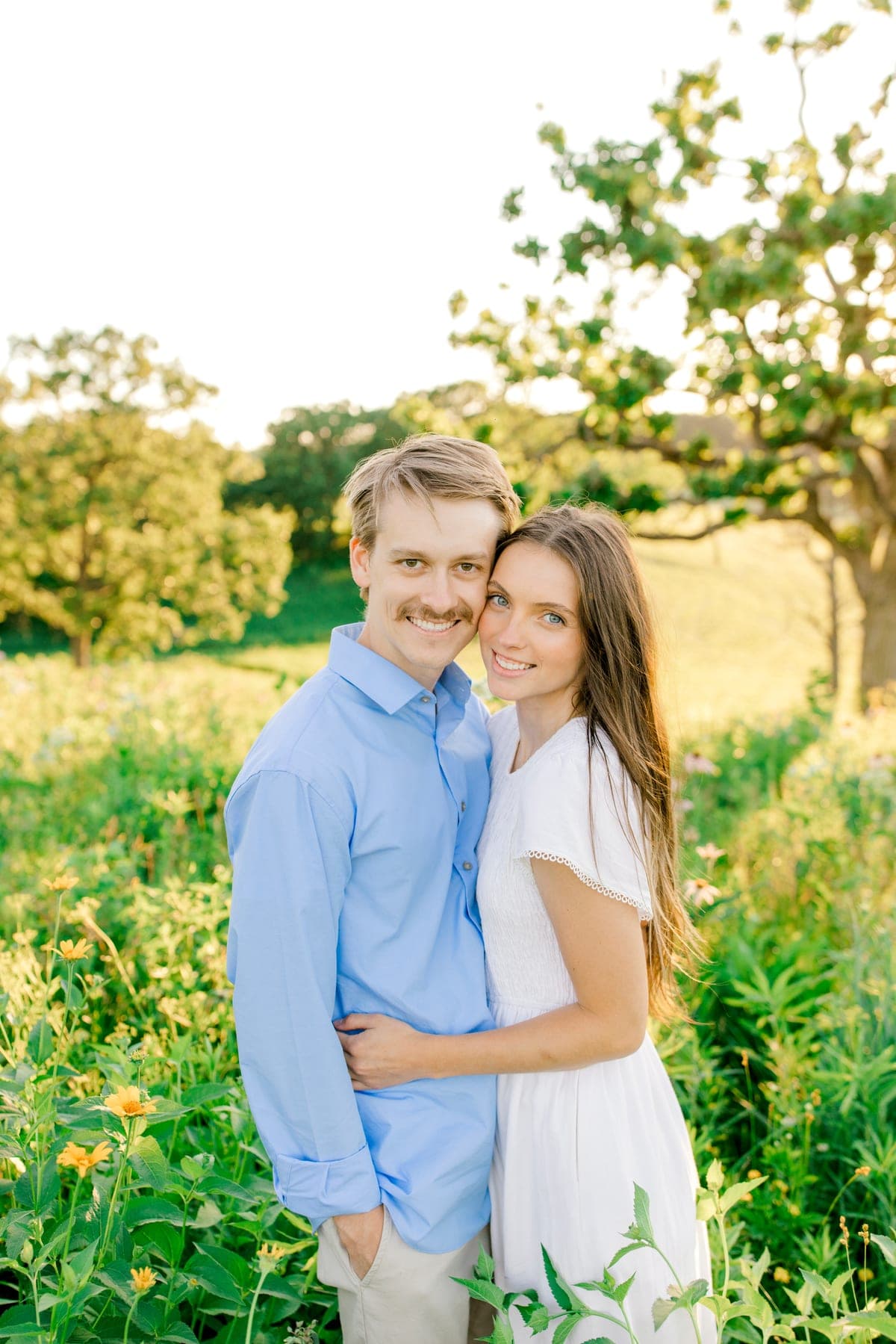 Jake and his wife standing together in a field of wildflowers